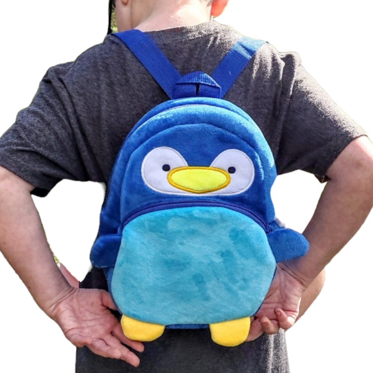 Child showing the size of the Penguin backpack Small child size.kpack showing
